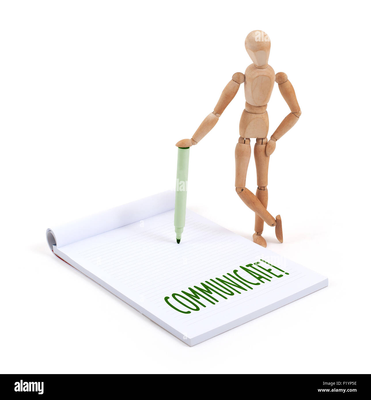 Wooden mannequin writing in a scrapbook - Communicate Stock Photo