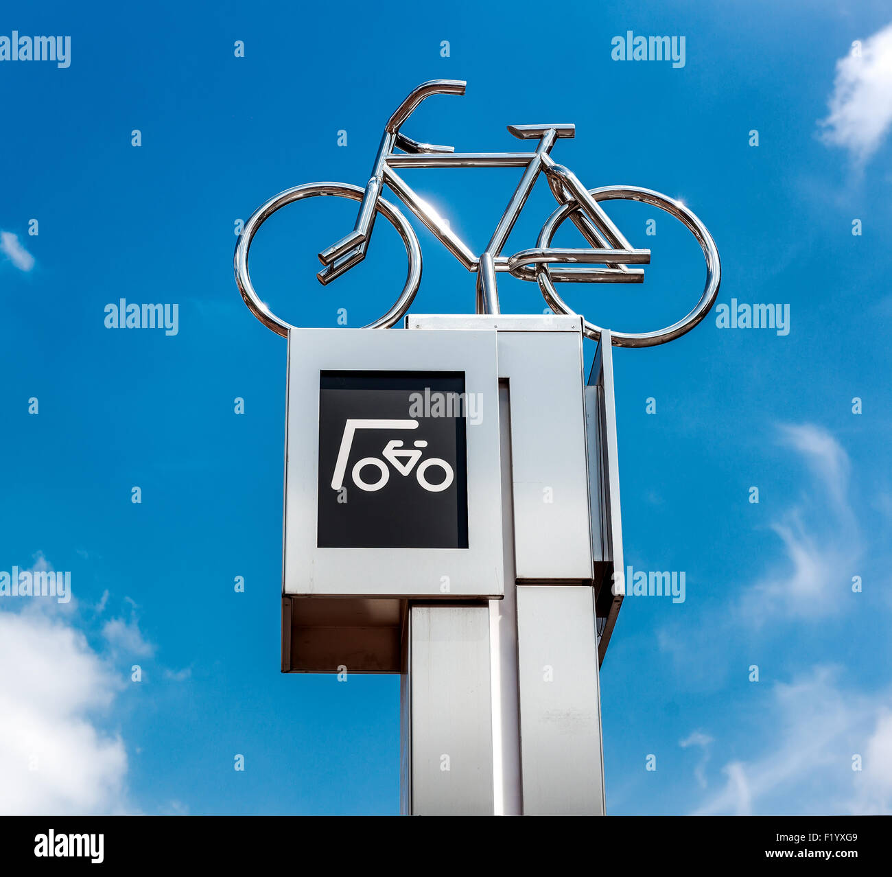 Bicycle parking sign against blue sky background Stock Photo