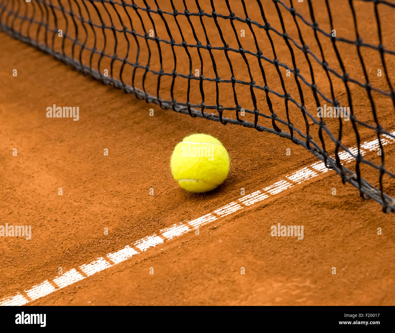 yellow tennis ball on a red clay court Stock Photo Alamy