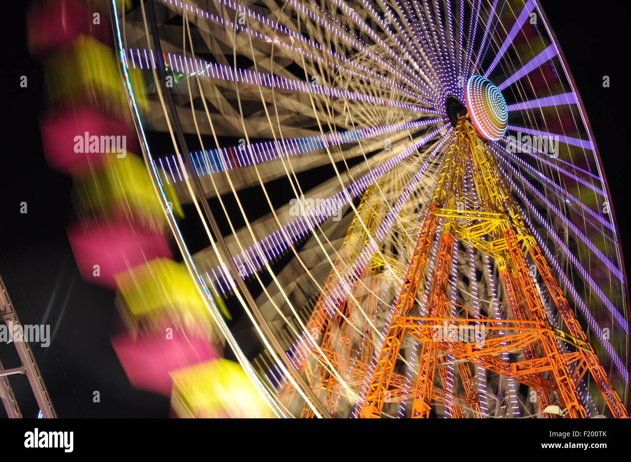 Striking time exposure shot of  fairground ferris wheel at night. brief exposure to show the excitement and movement of the ride Stock Photo