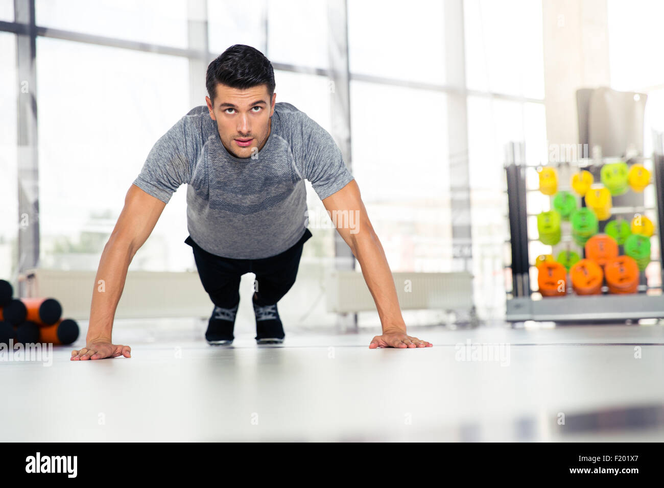 Portrait of a fitness man doing push-ups in gym Stock Photo