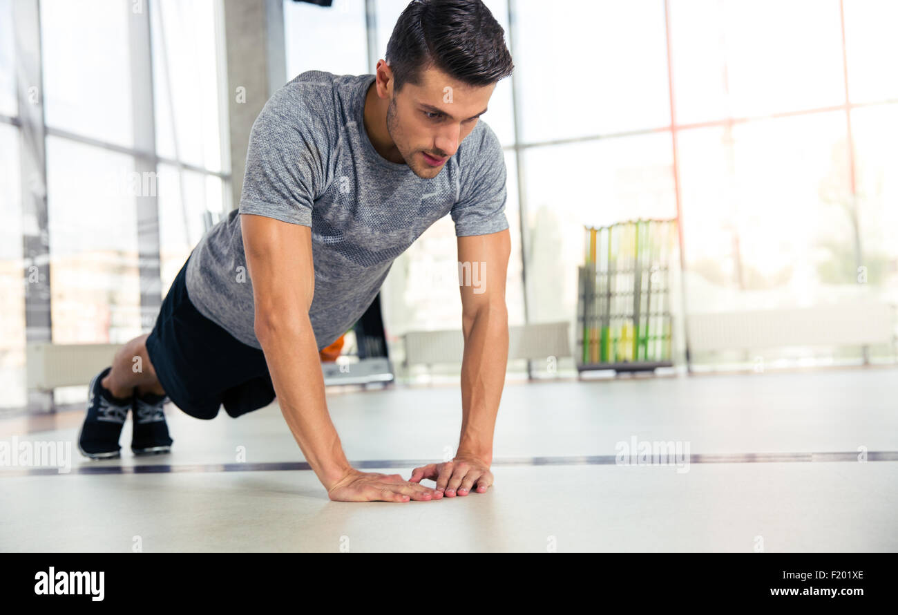 Portrait of a sportss man doing push-ups in gym Stock Photo