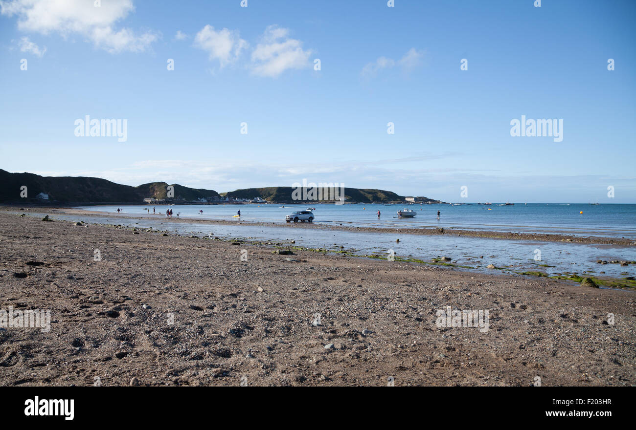 A man winches a speed boat onto a trailer attached to an Audi Q7 4x4 car on the beach at Morfa