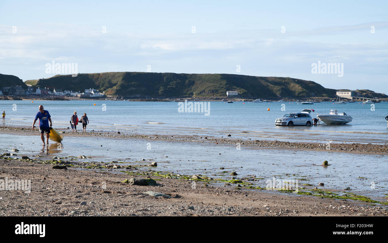 men winch a speed boat onto a trailer attached to an Audi Q7 4x4 car