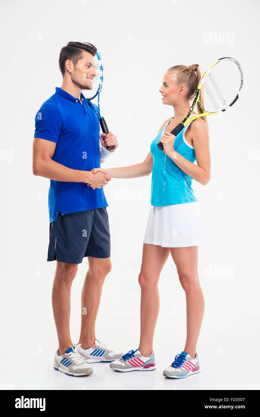 Full length portrait of a two tennis players making handshake isolated on a white background Stock Photo