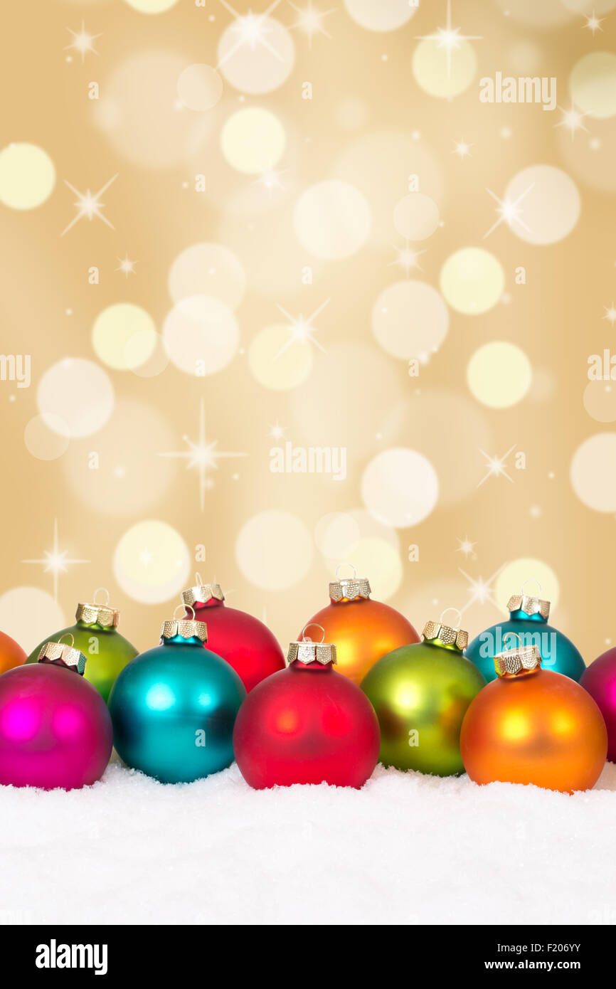 Many colorful Christmas balls golden background with snow and copyspace Stock Photo