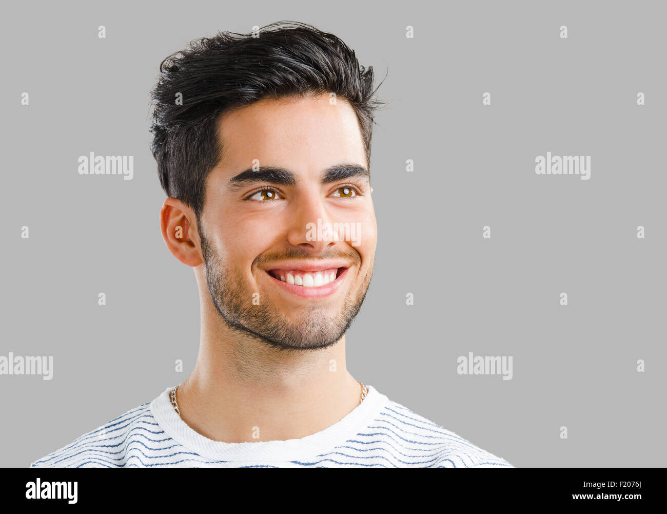Close-up portrait of handsome young man, isolated over a gray ...