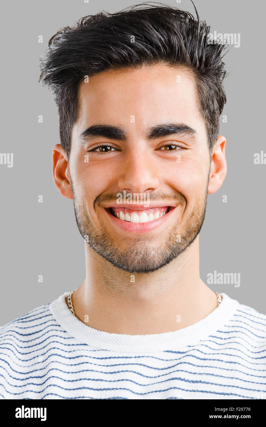 Close-up portrait of handsome young man, isolated over a gray ...