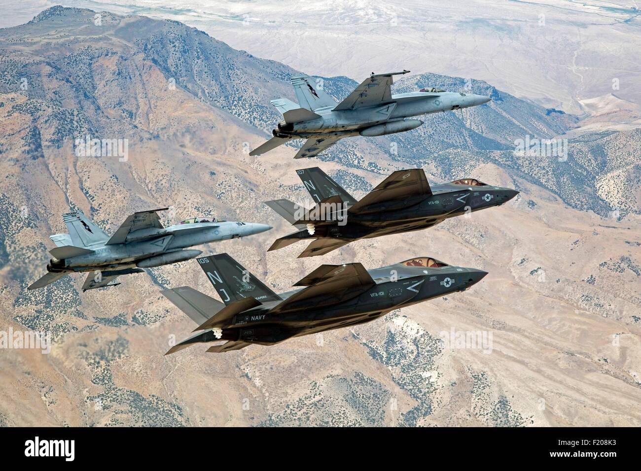 U.S. Navy F-35C Lightning II fighter aircraft fly in formation with Navy F/A-18E/F Super Hornets over Naval Air Station Fallon's Range Training Complex September 3, 2013 in Fallon, Nevada. Stock Photo