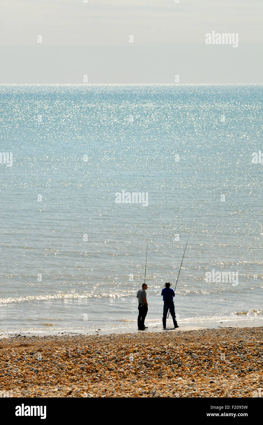 Bexhill-on-Sea, East Sussex, England, UK. Two men fishing on the beach Stock Photo