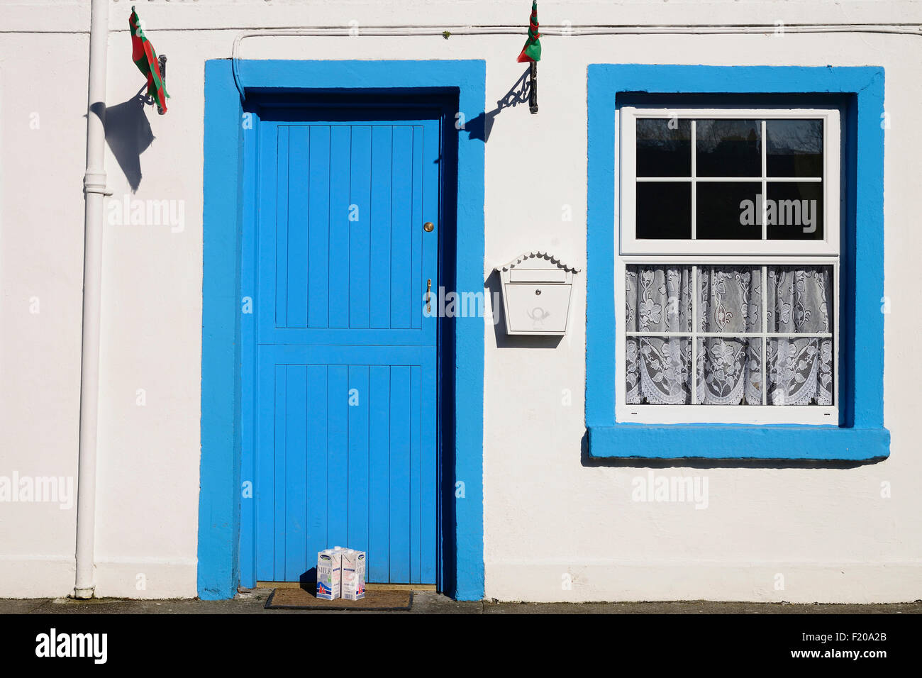 Ireland, County Mayo, Cong, Traditional house facade with cartons of milk outside the door. Stock Photo