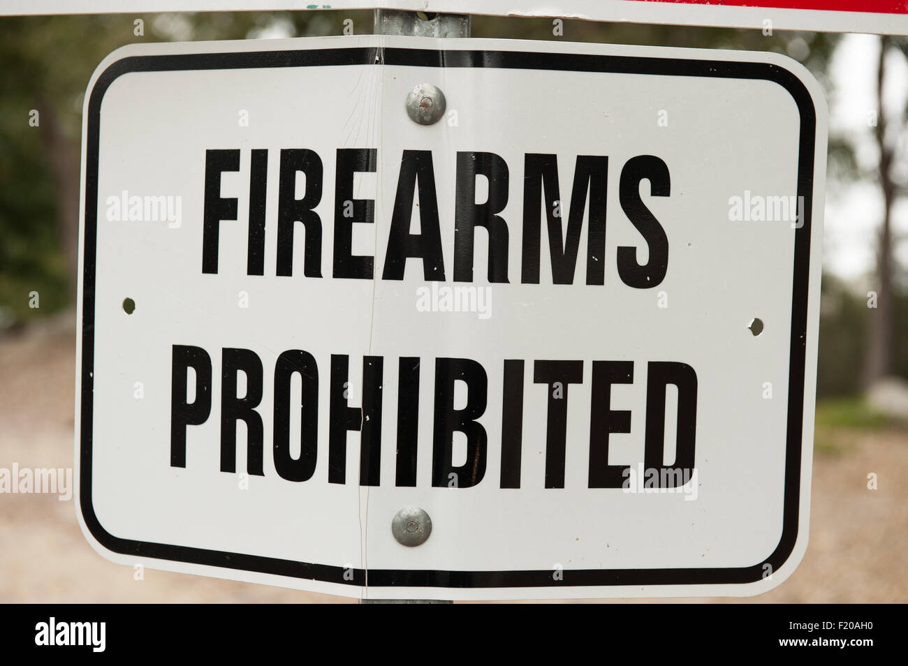 California, USA. Bent damaged 'Firearms Prohibited' road sign. Stock Photo