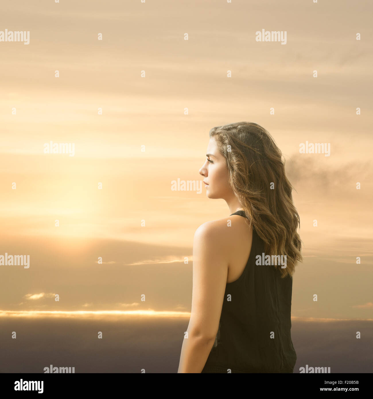 Young woman looking away at sunset Stock Photo - Alamy
