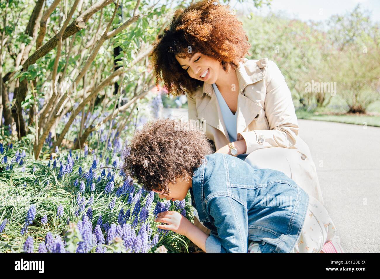 Mother and daughter bending over smelling flowers Stock Photo Alamy