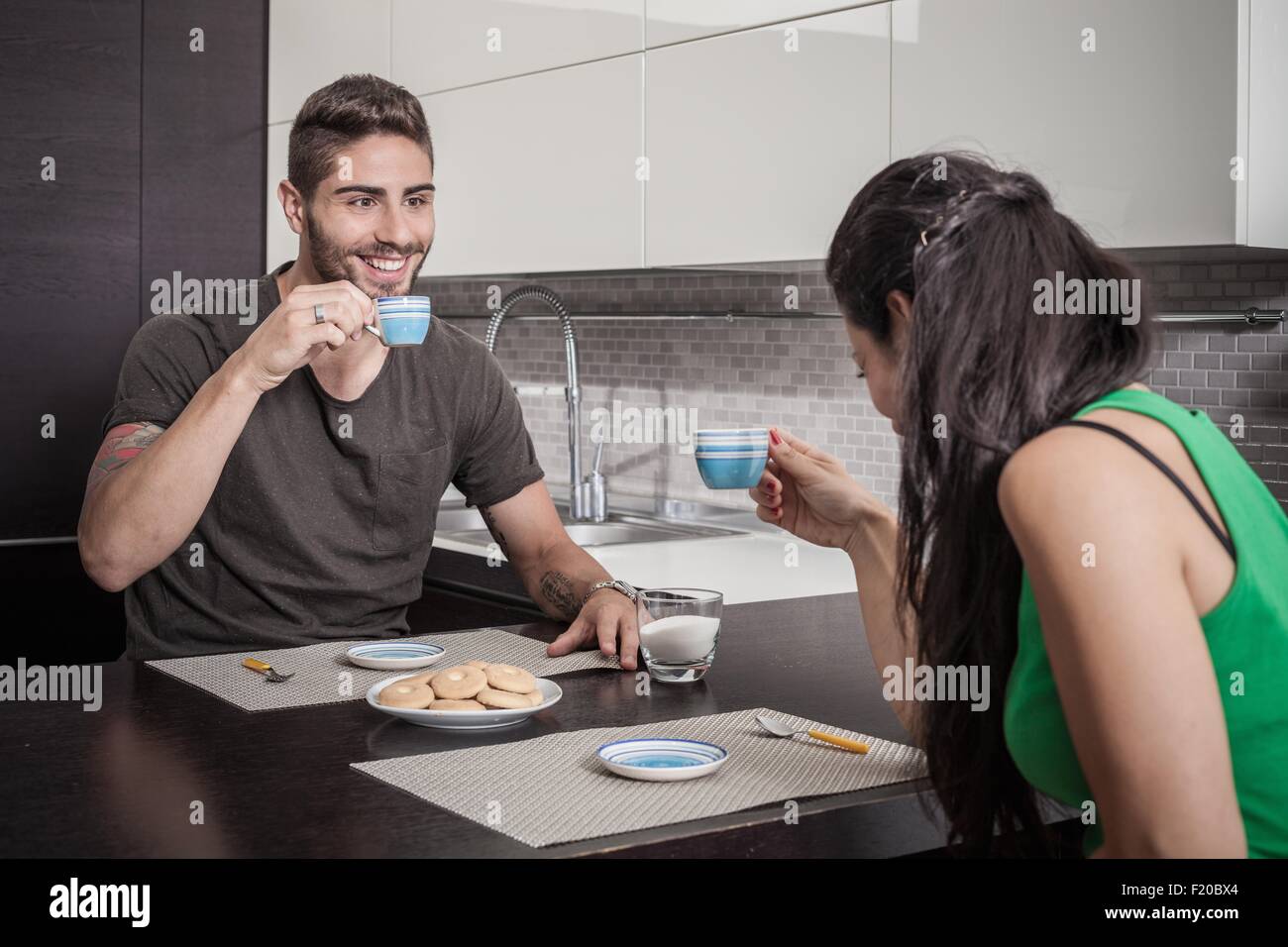Young couple drinking coffee at breakfast bar Stock Photo