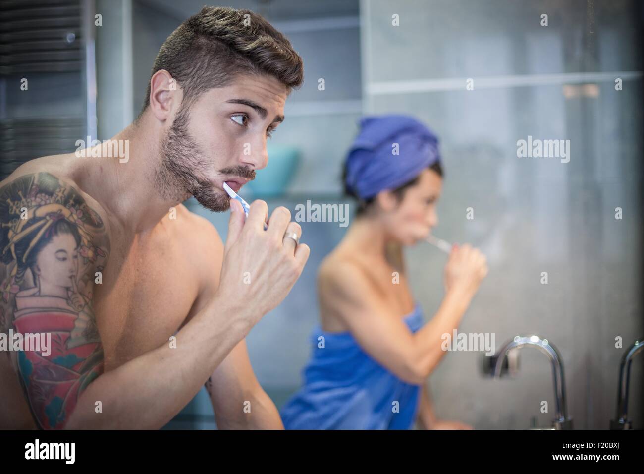 Young couple brushing teeth in bathroom Stock Photo