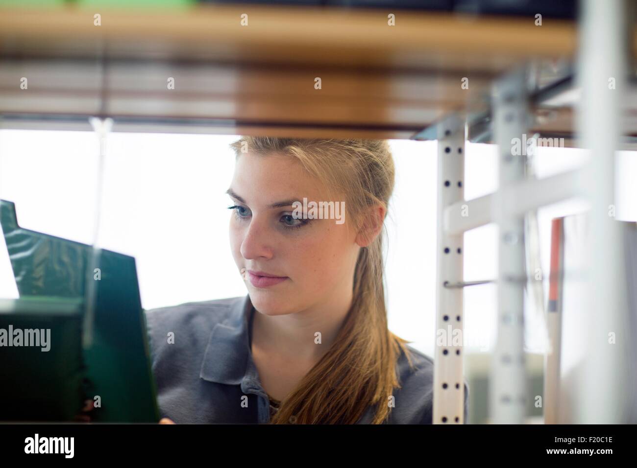 Young female student searching for textbook in library Stock Photo