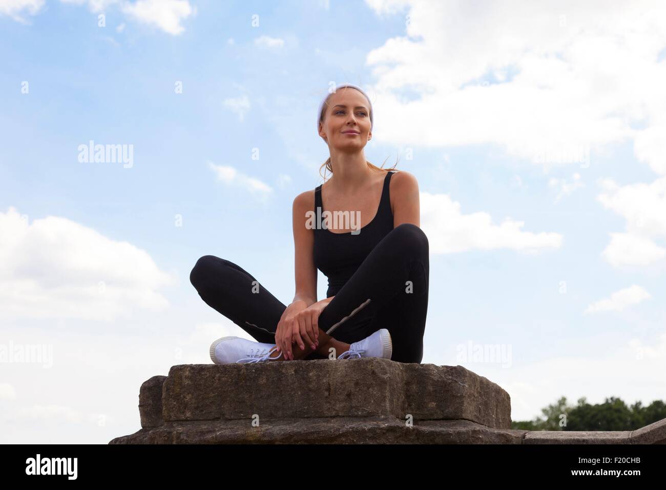 Portrait of woman sitting on pedestal Stock Photo Alamy