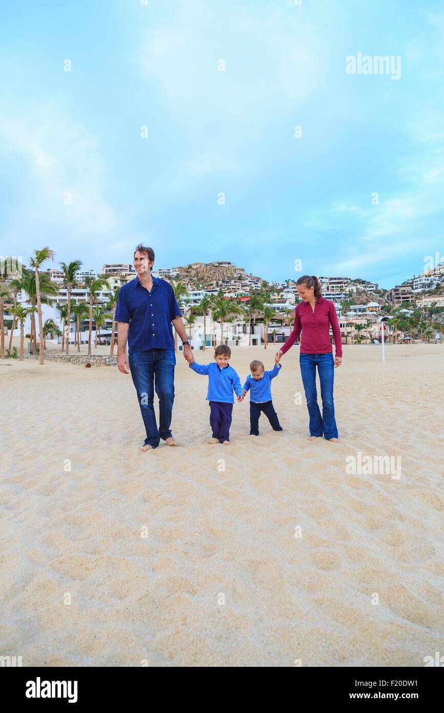 Young family, walking on beach, holding hands Stock Photo
