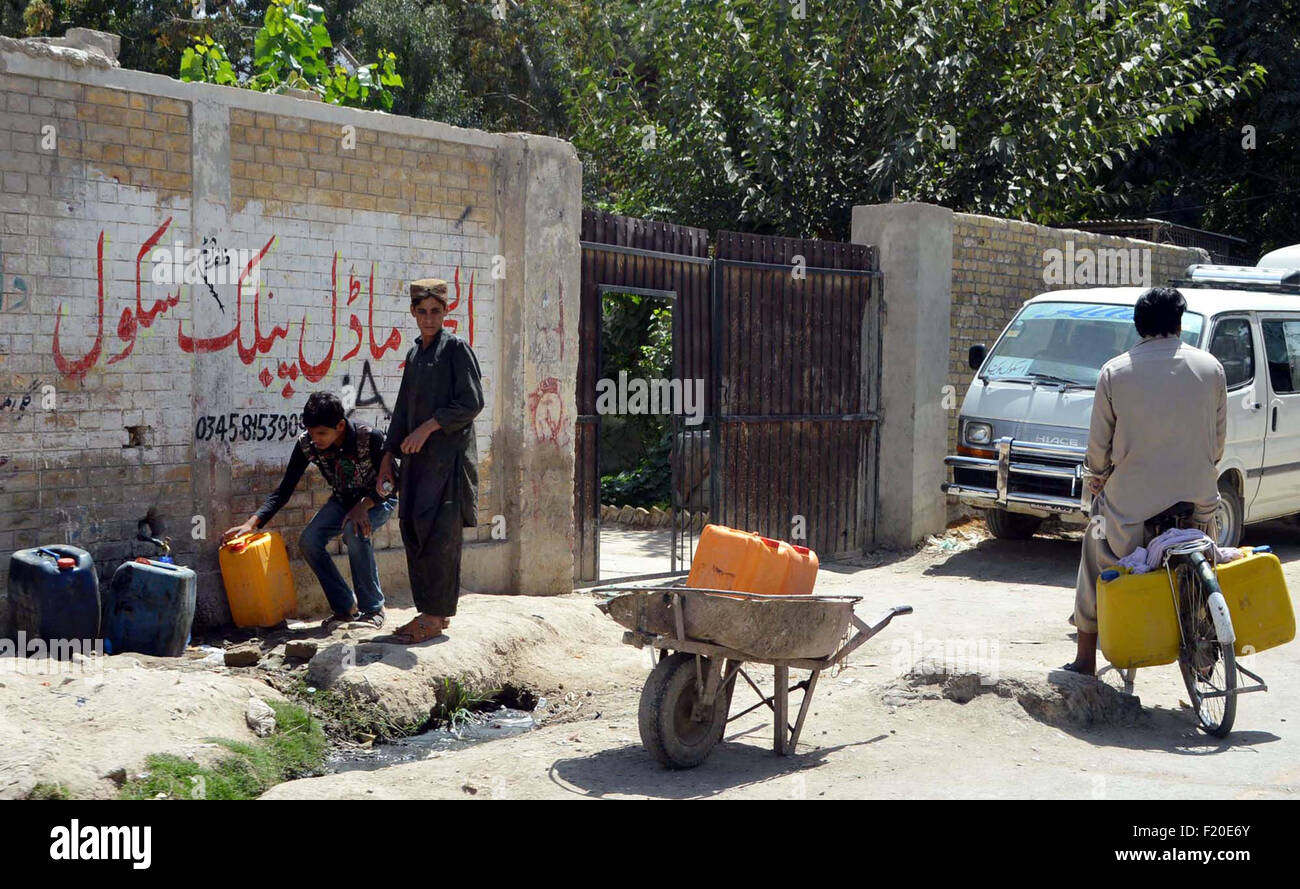 Residents of Quetta are filling their drinking water pots due to shortage of drinking water in city and electricity load shedding for long time, at a filter plant in Quetta on Wednesday, September 09, 2015. Stock Photo