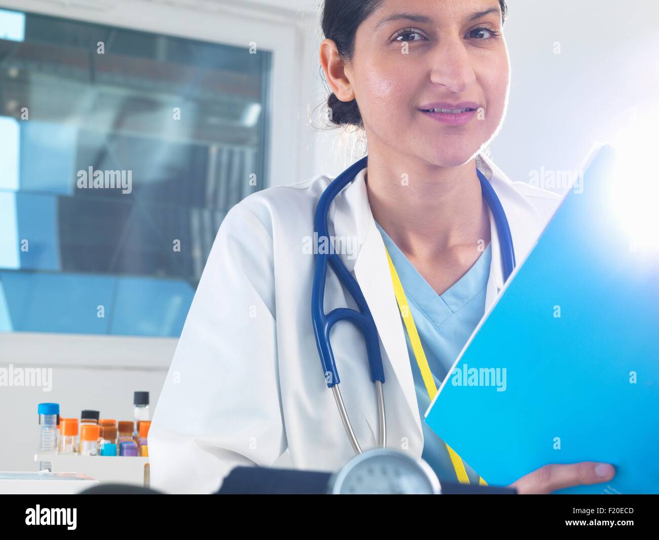Portrait of female doctor holding medical notes in hospital Stock Photo