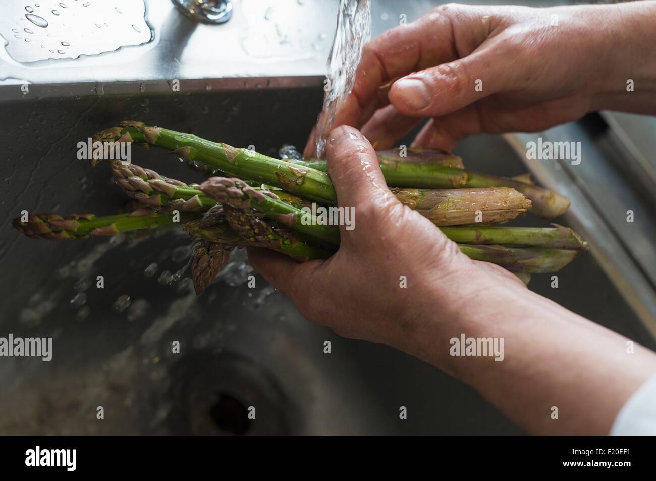 Washing asparagus, focus on hands Stock Photo
