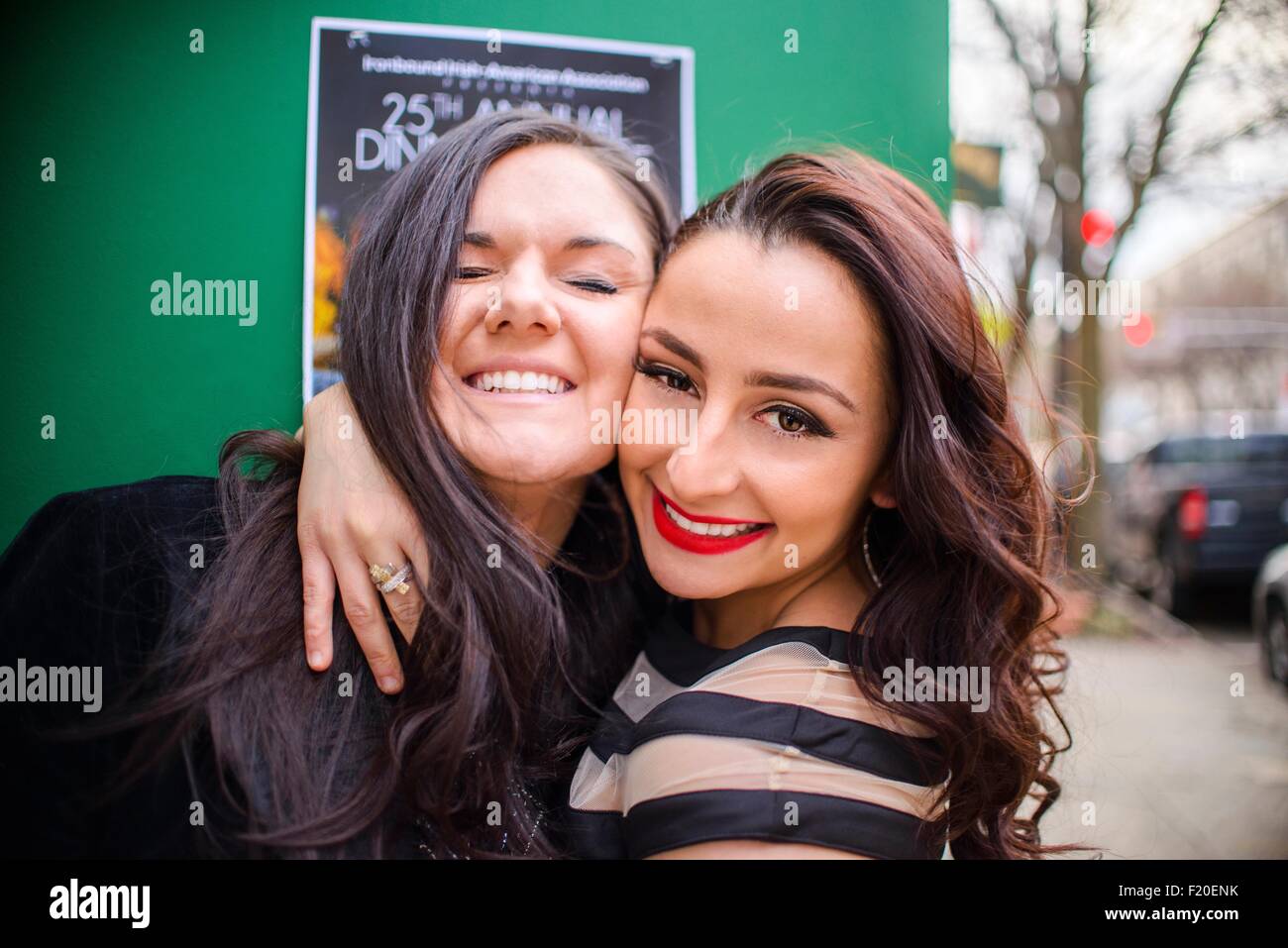 Portrait of two young adult female friends hugging on street Stock Photo