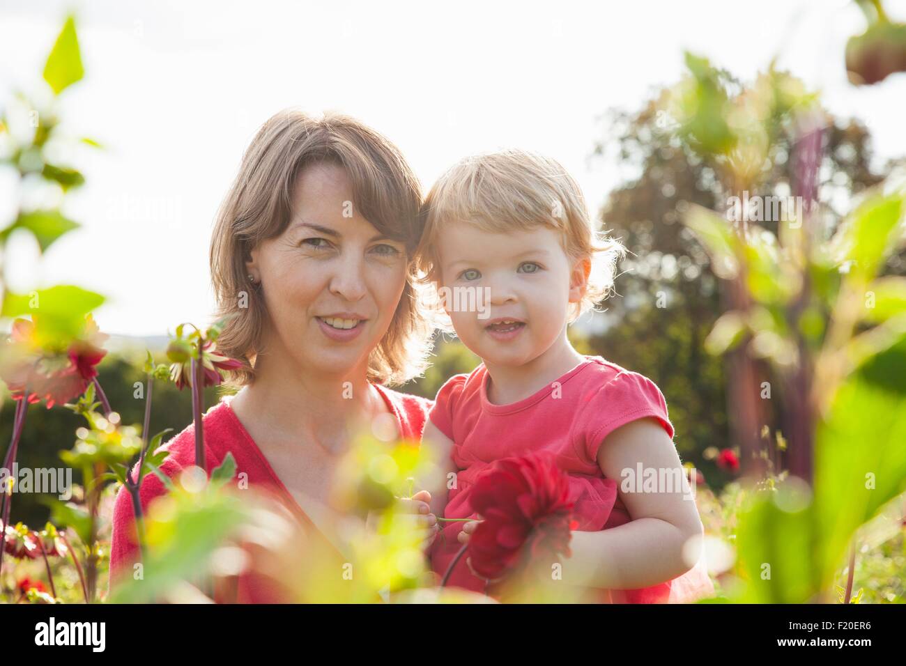 Portrait of mid adult mother and toddler daughter in flower field Stock Photo