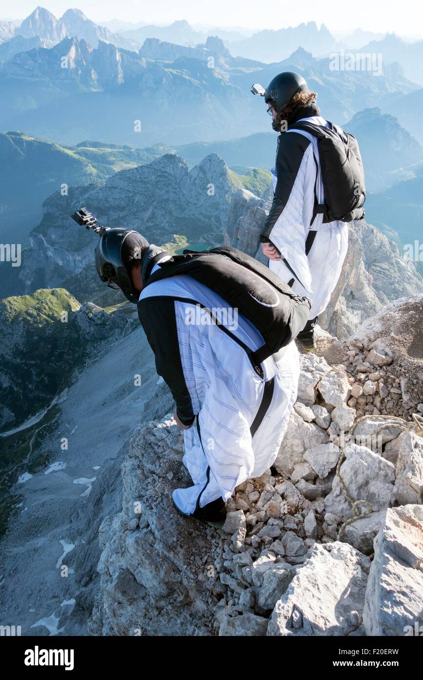 Two male BASE jumpers preparing to launch from mountain, Dolomites, Italy Stock Photo