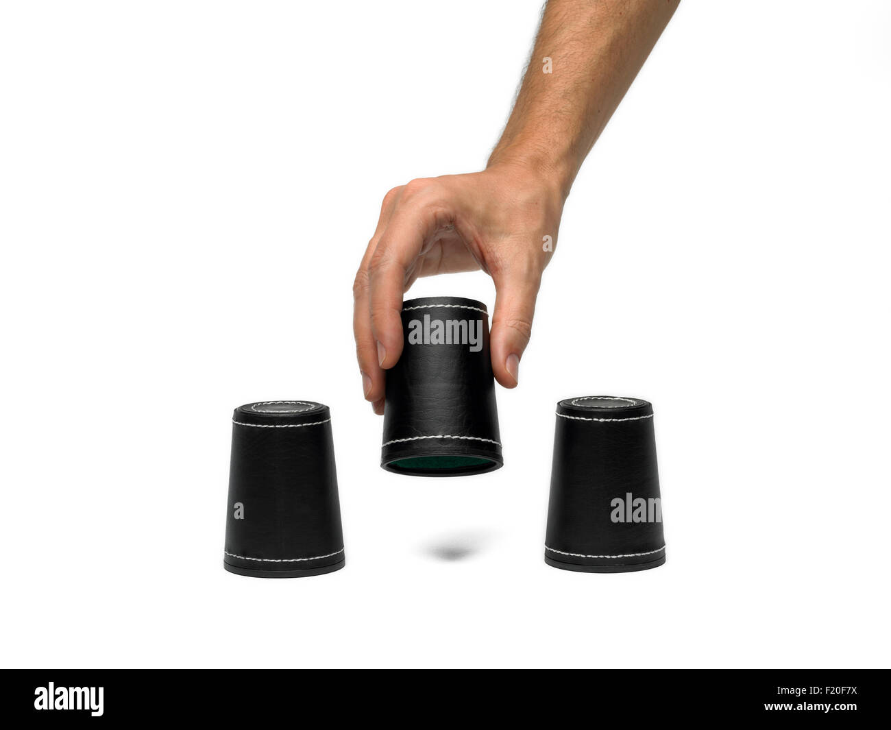 Various dice cups with hand on isolated white background Stock Photo