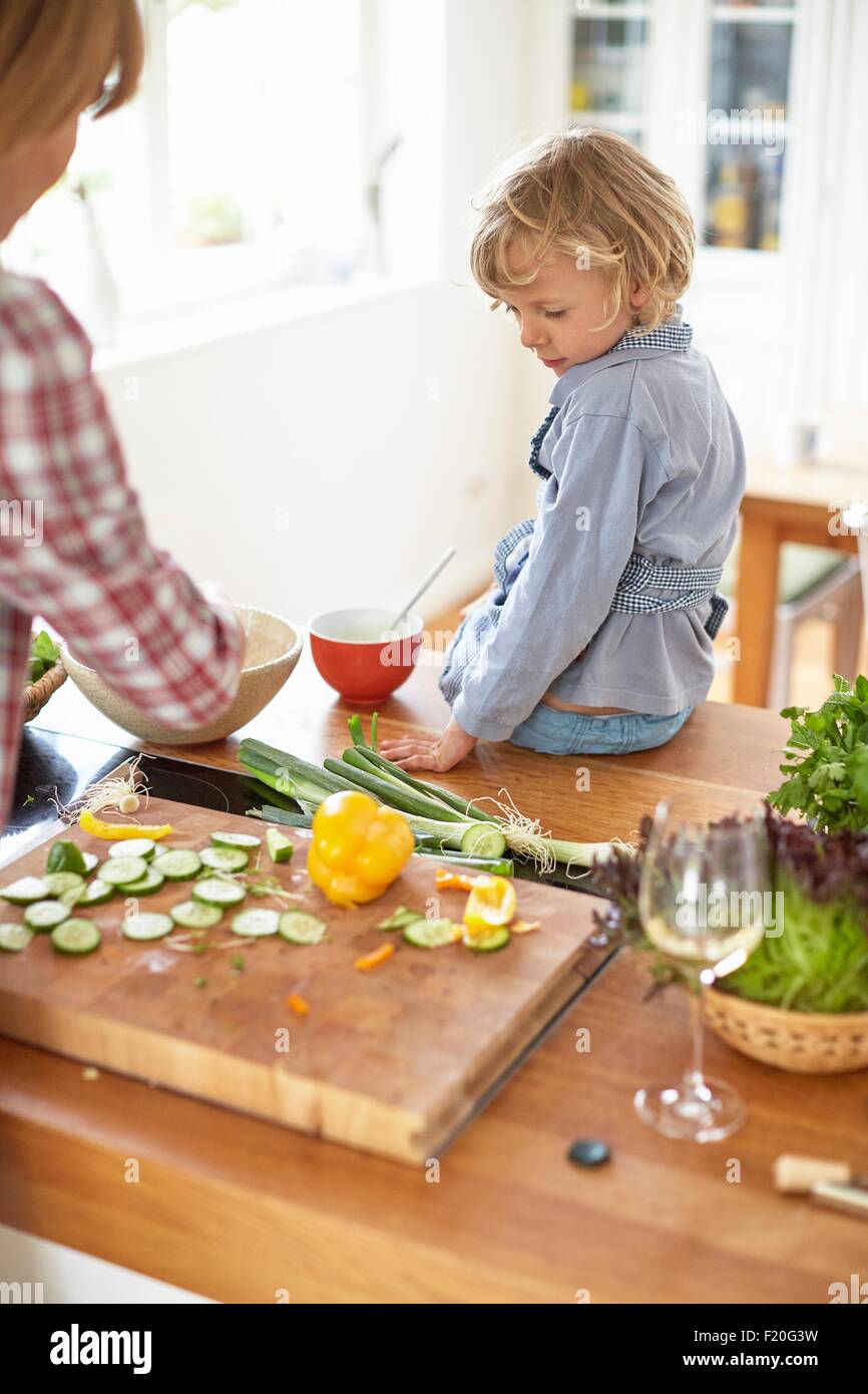 Mother and son preparing meal in kitchen Stock Photo