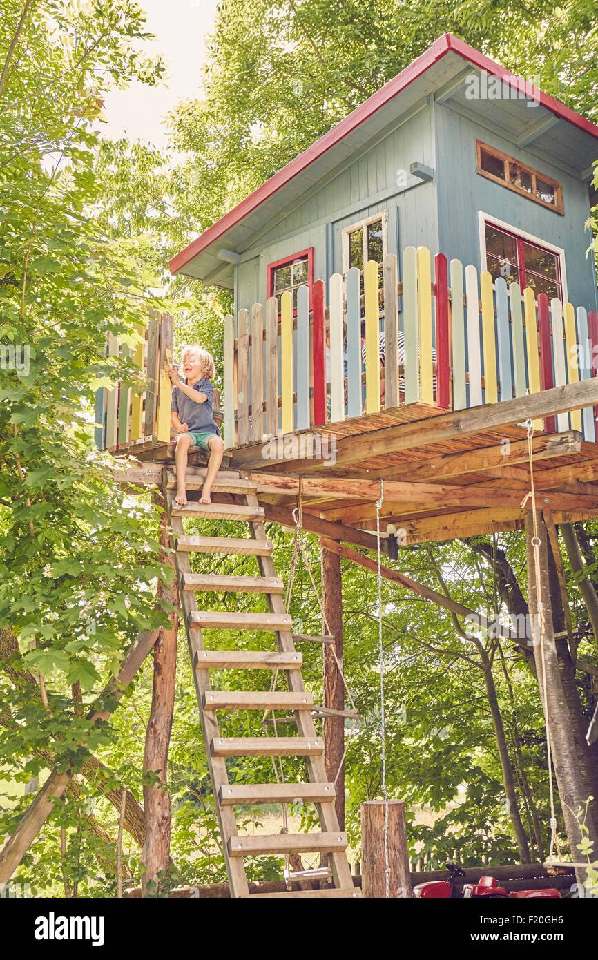 Young boy painting tree house Stock Photo