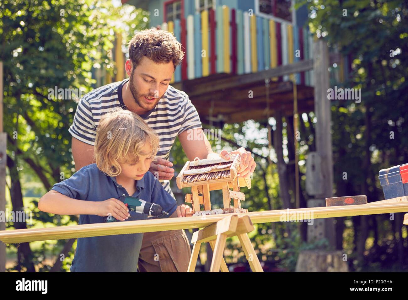 Father and son doing woodwork together, outdoors Stock Photo