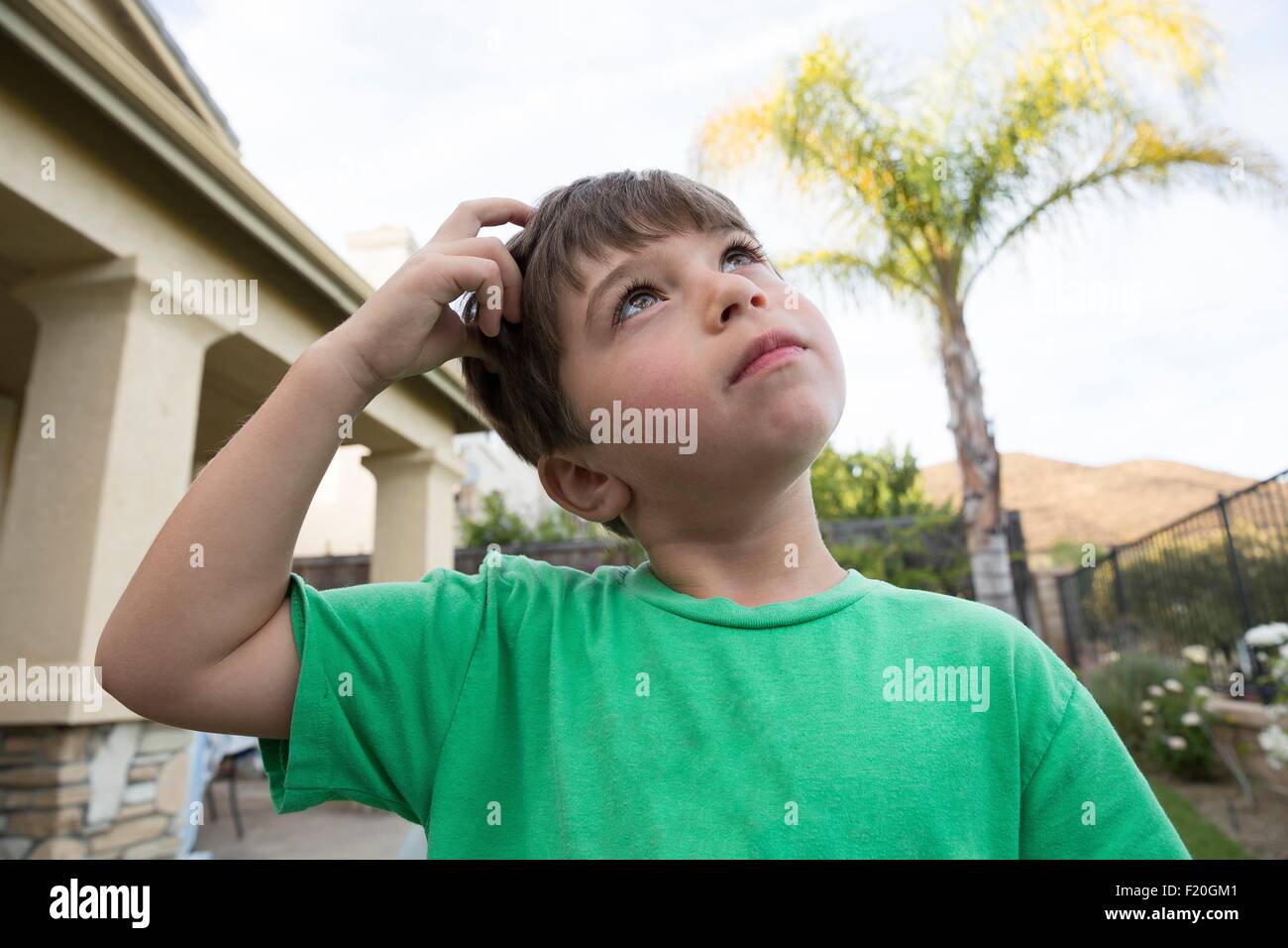 Portrait of young boy, scratching head Stock Photo