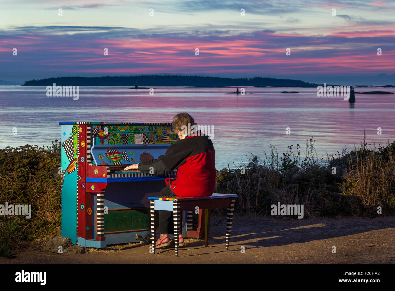 Senior citizen woman playing colorful piano at pre sunrise-Victoria, British Columbia, Canada. Stock Photo