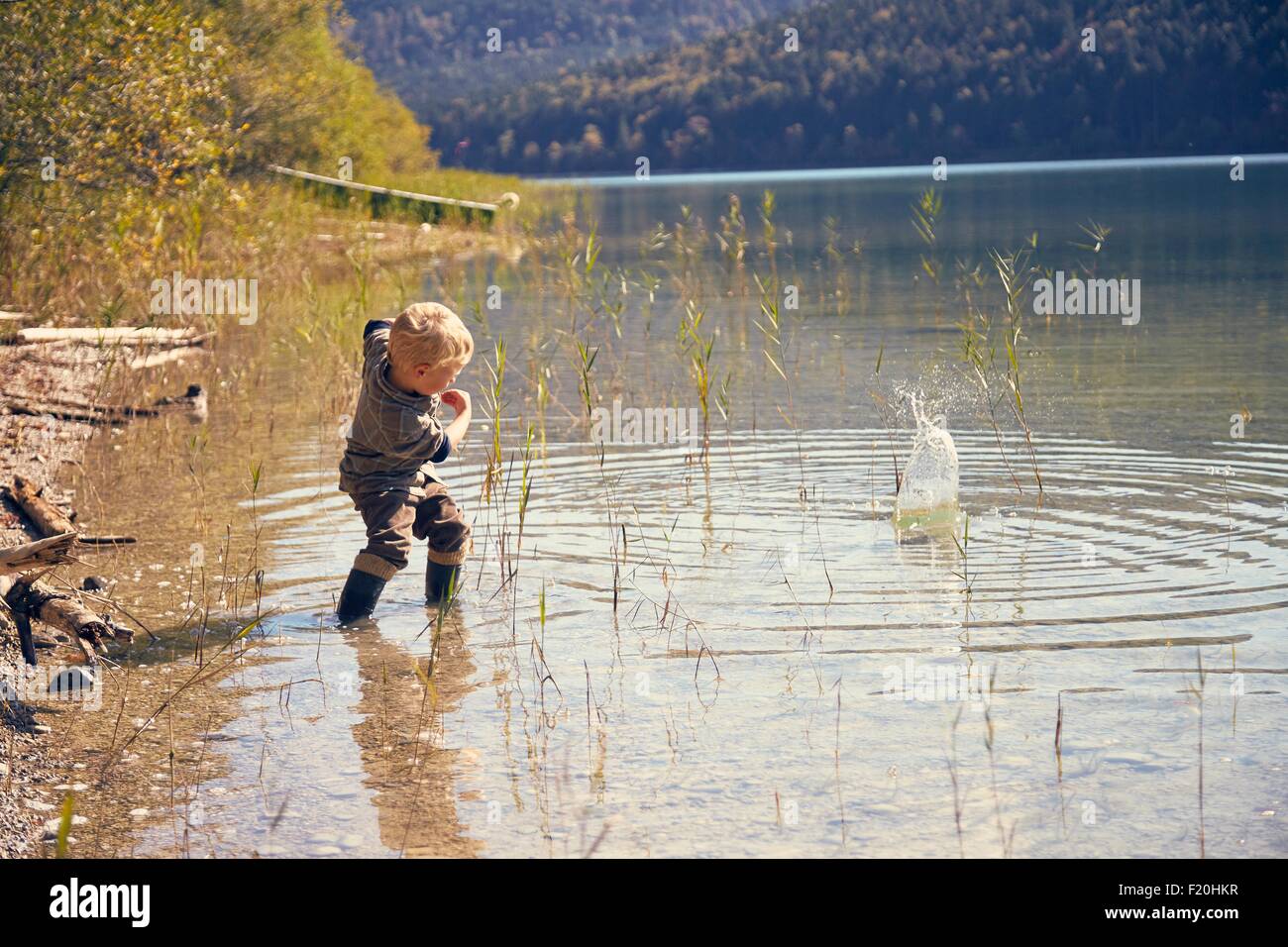 Boy skimming stones in lake, Kochel, Bavaria, Germany Stock Photo