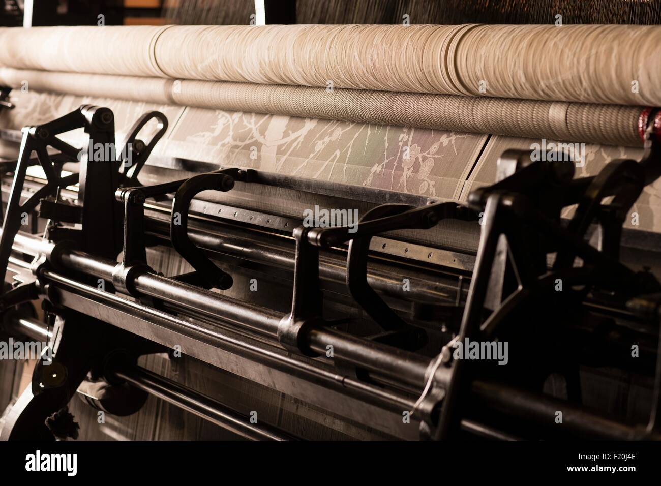 Roll of lace on old weaving machine in textile mill Stock Photo