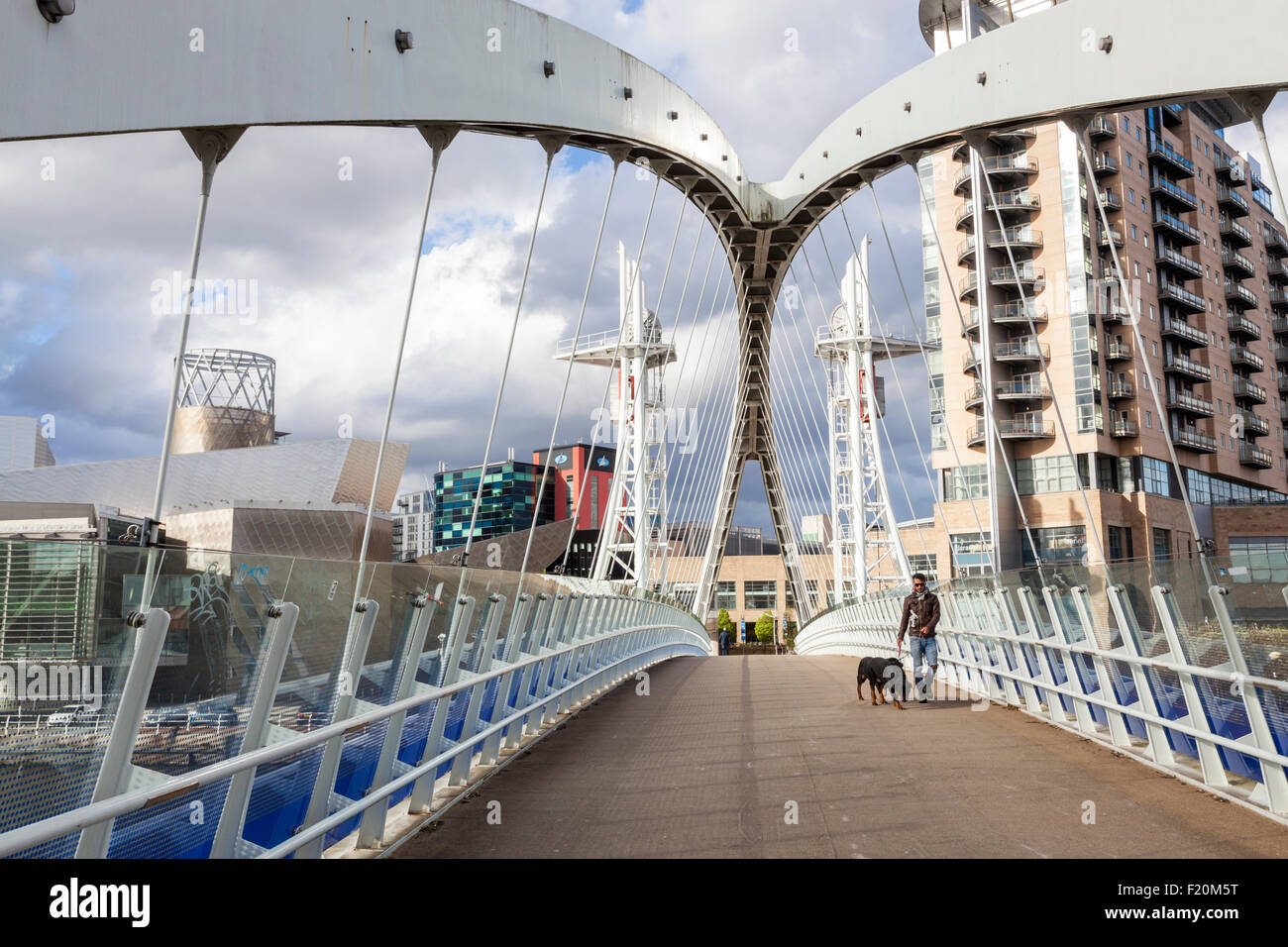A person crossing the Salford Quays lift bridge also known as the Lowry Bridge or Millennium footbridge, Salford Quays, Manchester, England, UK Stock Photo