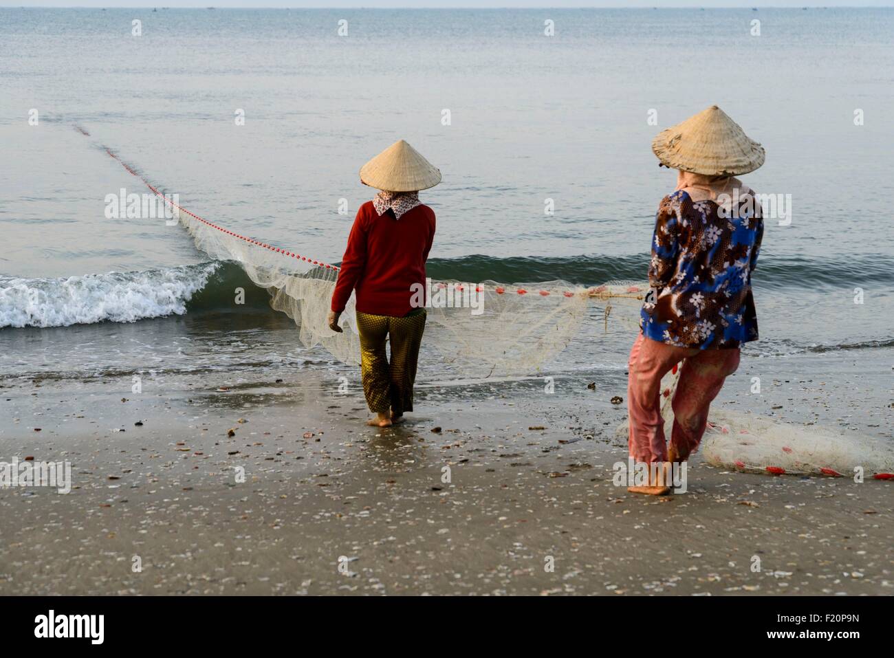 Vietnam, Mui Ne, hauling fish net on the beach Stock Photo
