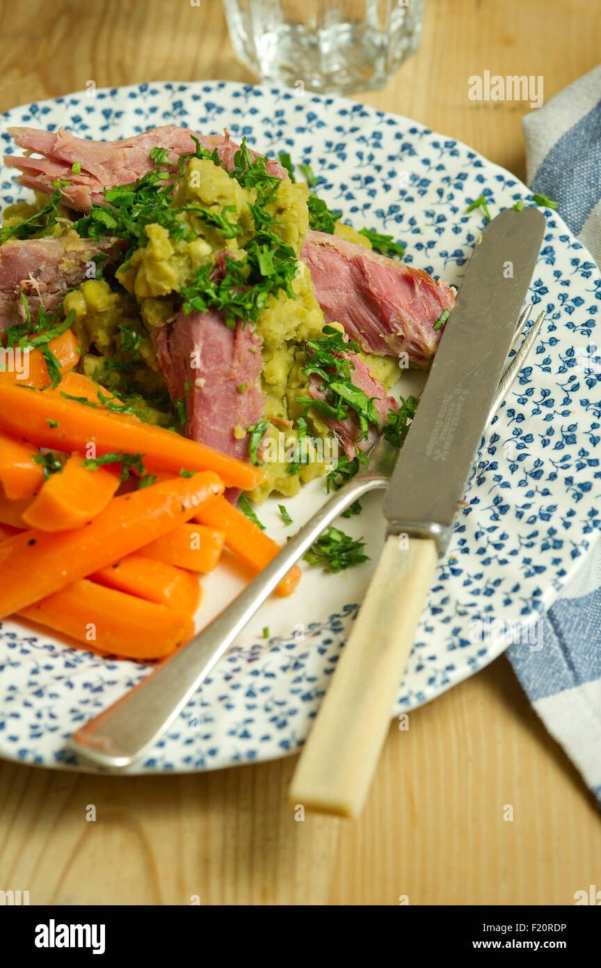 Ham hock with split peas and carrots. a UK lunch dinner meal cooking cuisine plate dish Stock Photo