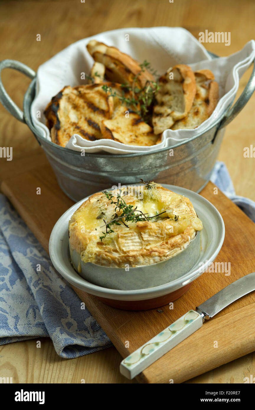 Baked Camembert cheese, served with garlic toast, usually as a starter in a three course meal. a UK baking food meal eating Stock Photo