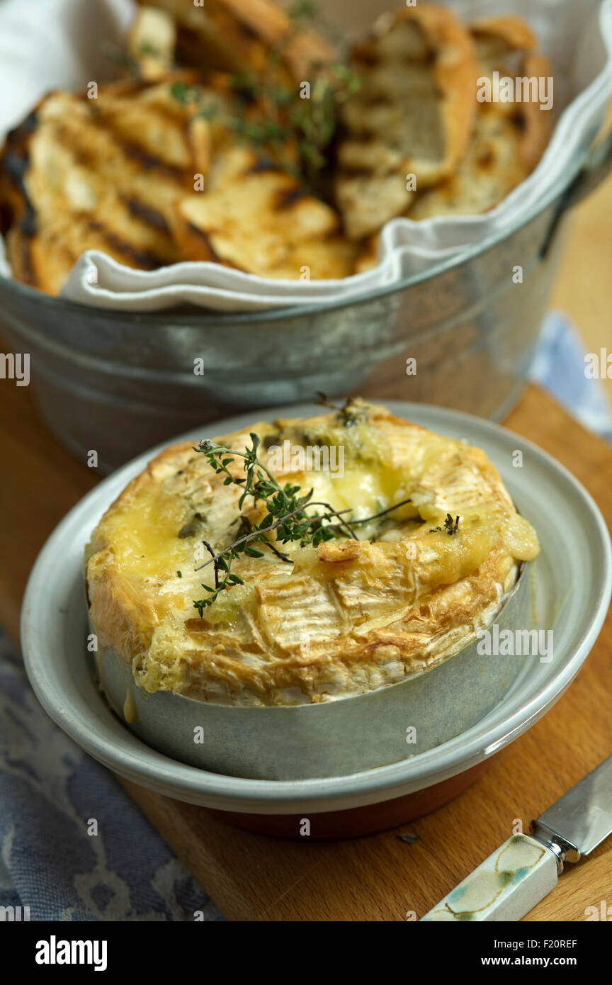 Baked Camembert cheese, served with garlic toast, usually as a starter in a three course meal. a UK baking food meal eating Stock Photo
