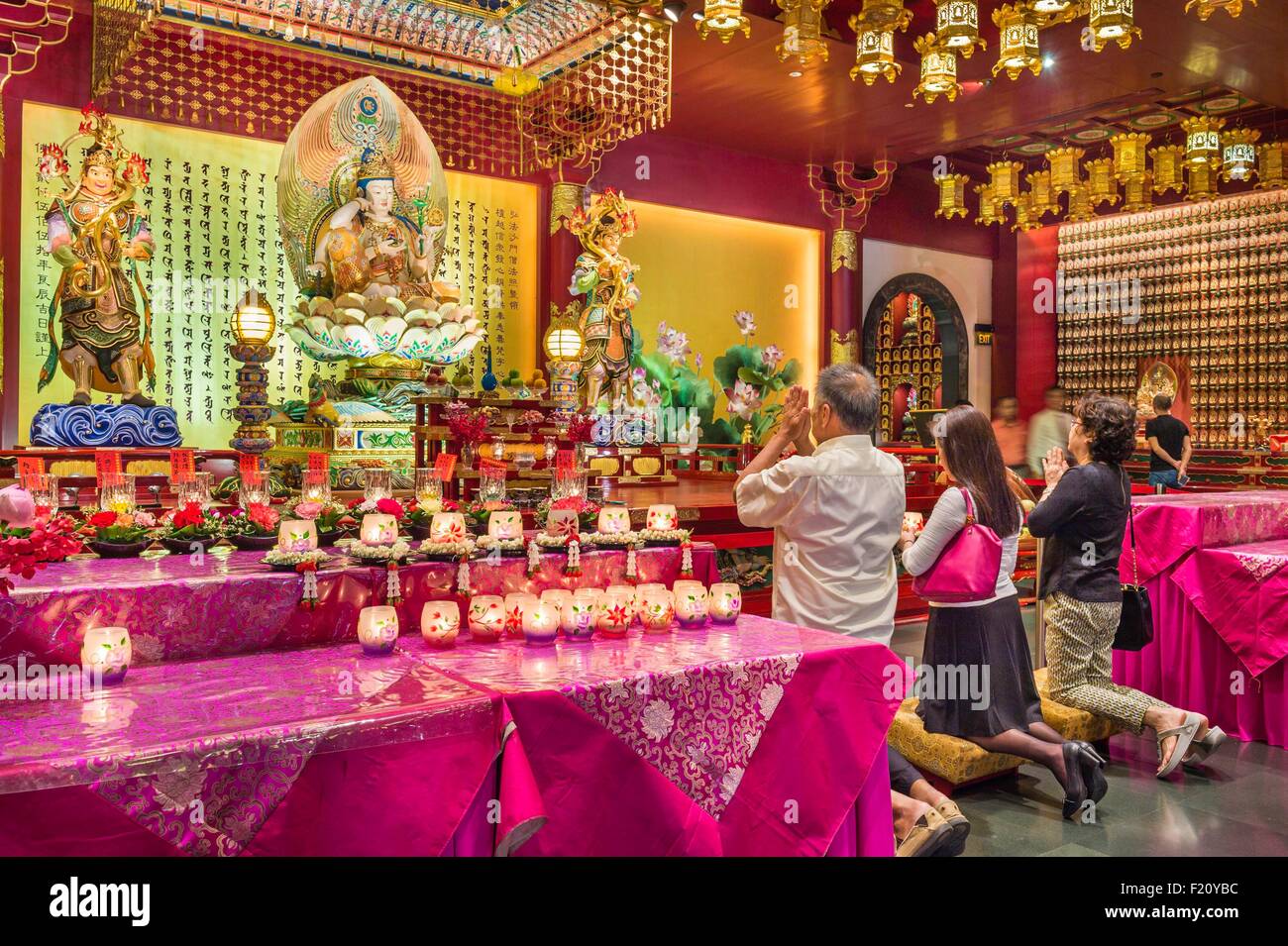 Singapore, Chinatown, Buddha Tooth Relic Buddhist temple, buddhists praying in front of Buddha Bodhisattva Cintamanicakra Avalokitesvara Stock Photo