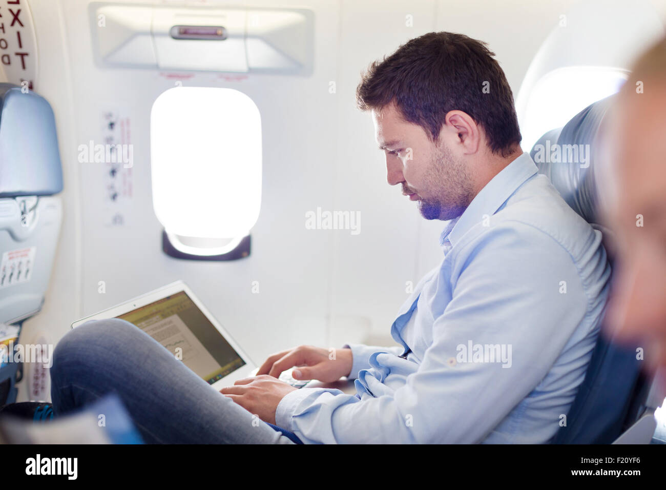 Businessman working with laptop on airplane Stock Photo Alamy