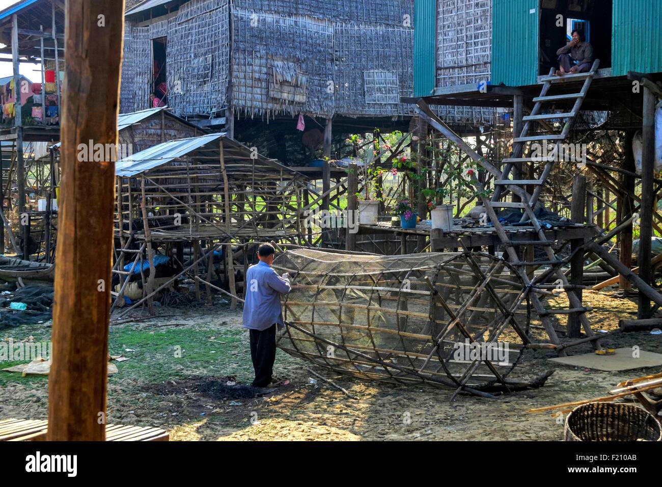 Cambodia, Kompong Kleang, stilt houses village along the Tonle Sap lake, fisherman repairing his fish trap Stock Photo