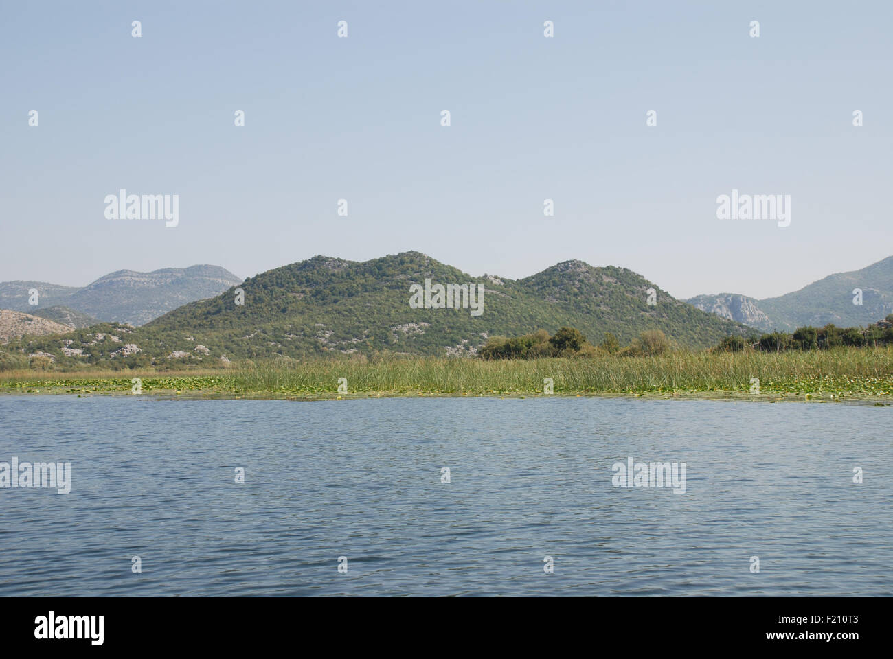 Limestone mountains rise above the water of Skadar lake in Montenegro Stock Photo
