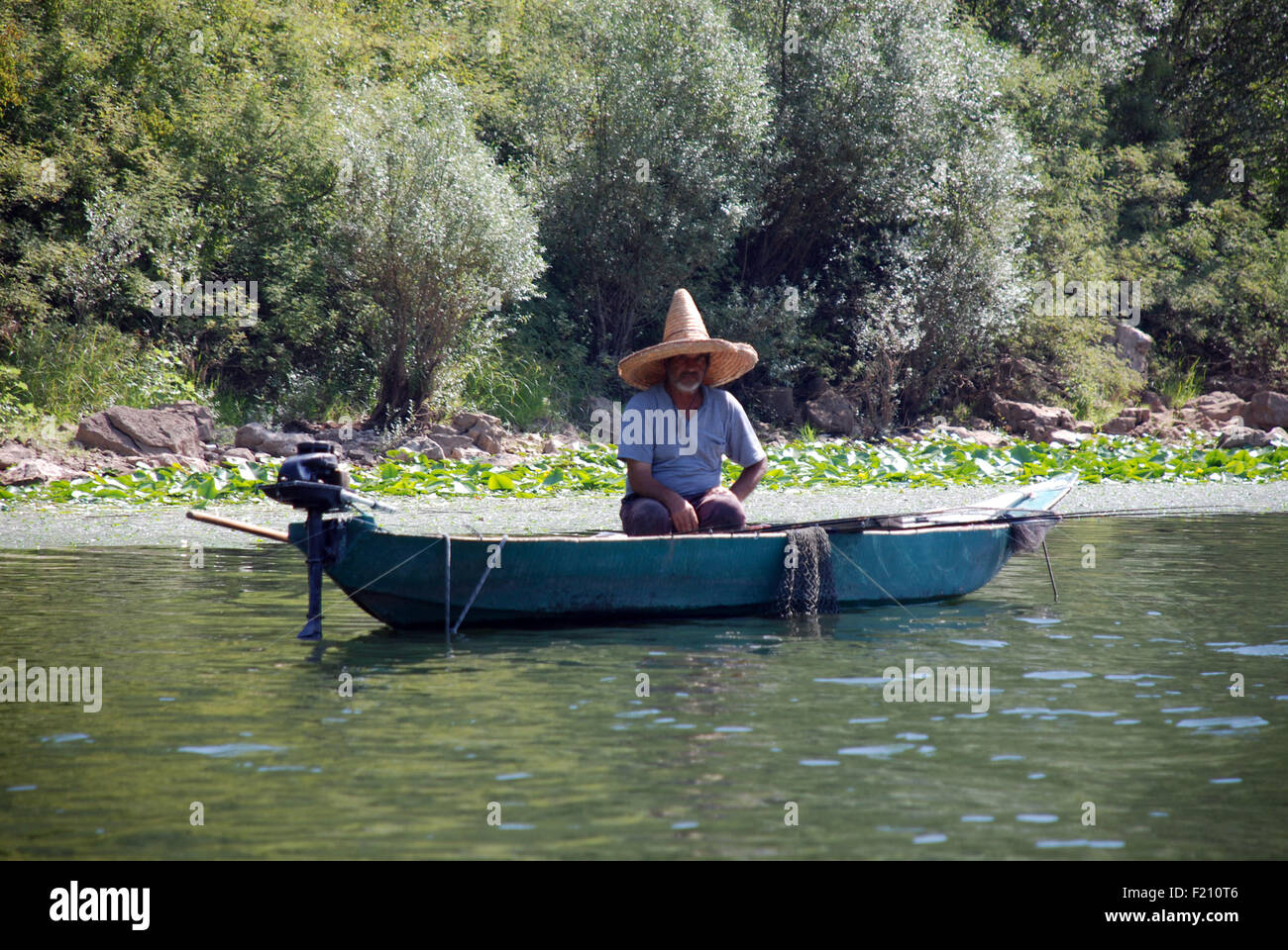 A man in a small boat fishing on Skadar lake in Montenegro Stock Photo