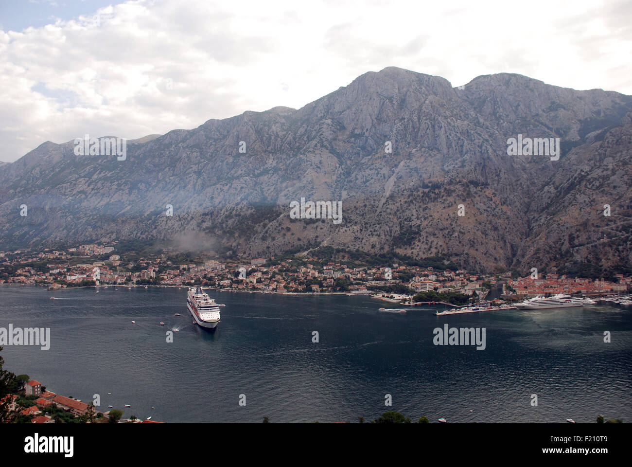 A large cruise ship in  Kotor Bay outside the old town of Kotor in Montenegro with limestone mountains in the background Stock Photo
