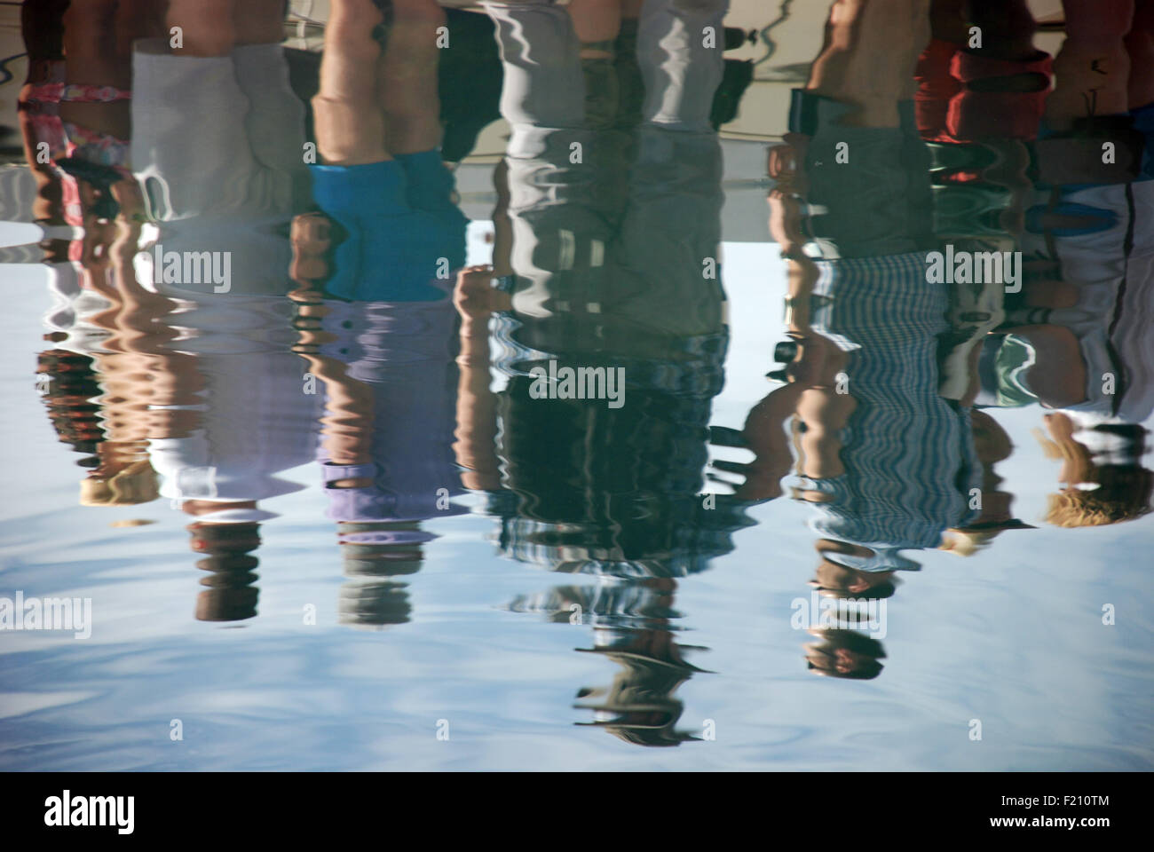 tourists are reflected in the water of Kotor Bay in Montenegro as they board a tour boat Stock Photo
