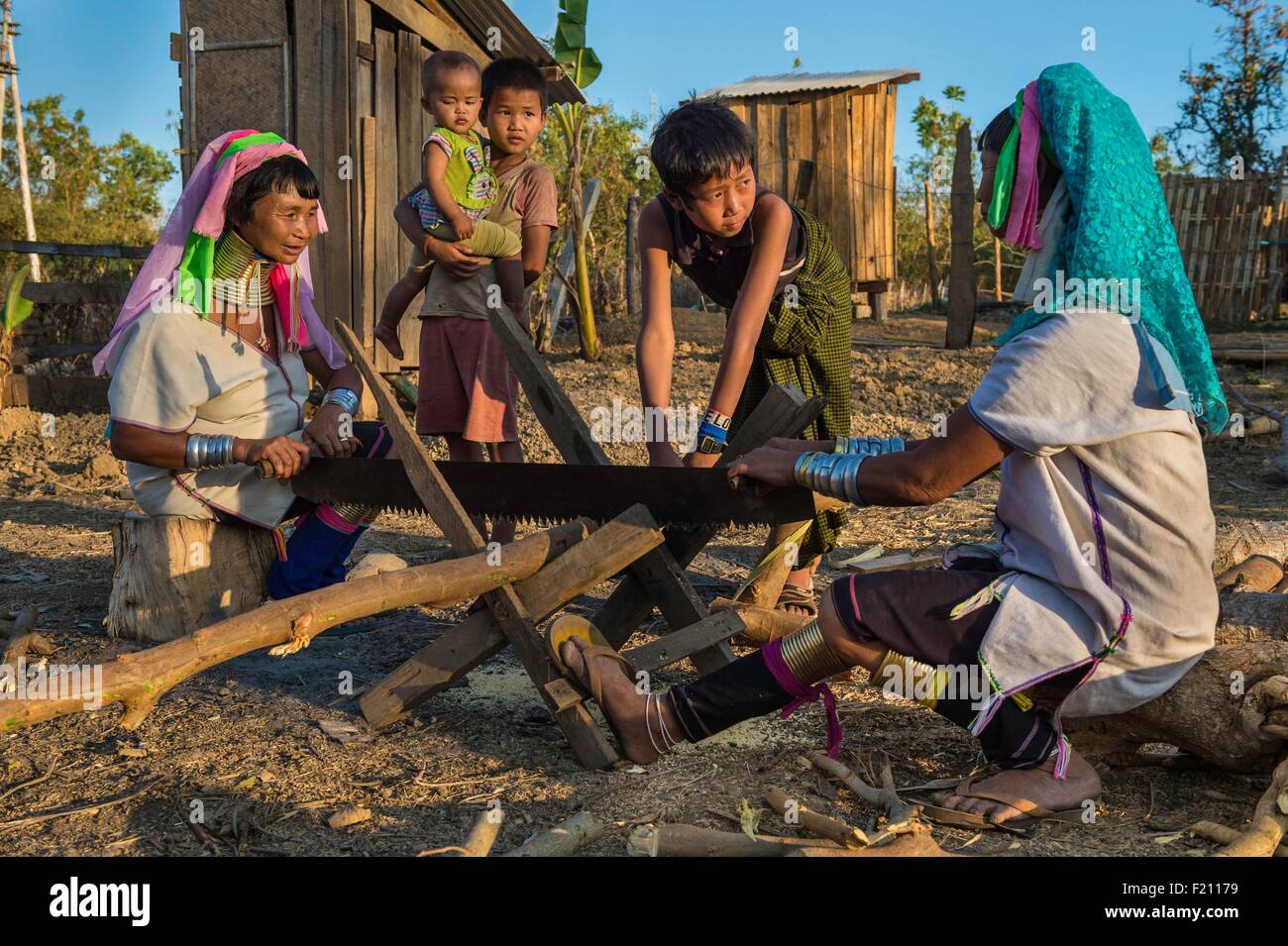 Myanmar (Burma), Kayah state, Loikaw area, Kayan tribe (Padaung) named tribe of 'giraffe women, Demawso, Moe Su and Moe Bu cutting wood Stock Photo